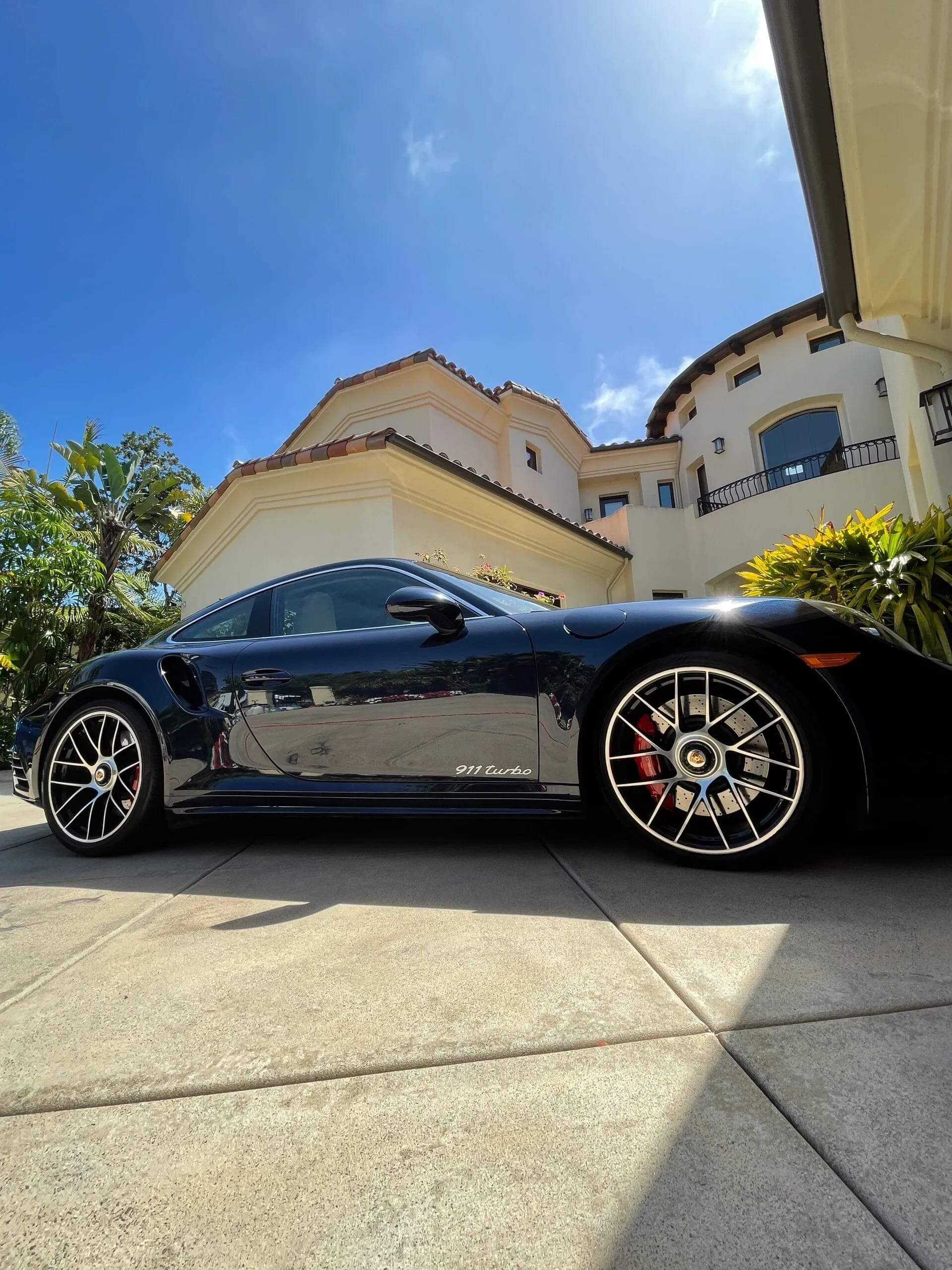 Dark Blue Porsche 911 Turbo parked infront of house and freshly detailed.