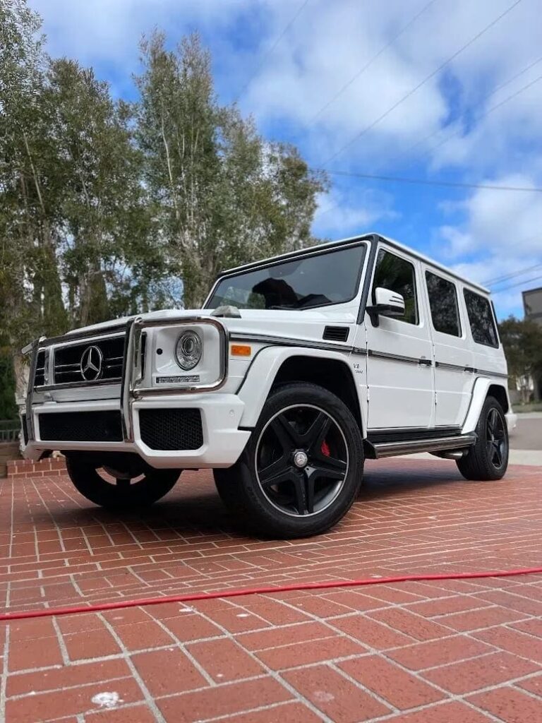 A clean white Mercedes parked in a driveway.