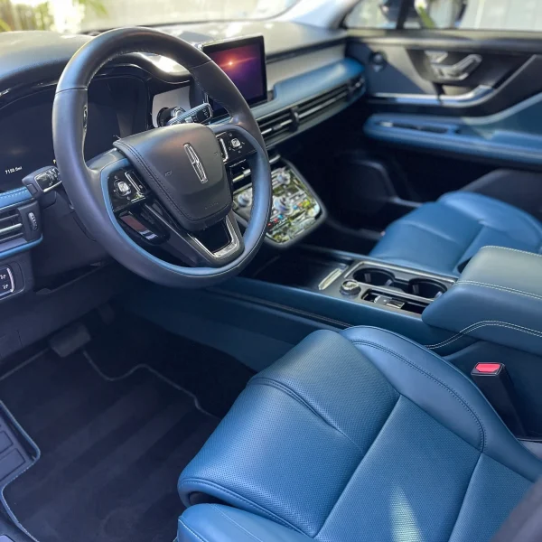 The interior of a Lincoln showcasing the driver seat and steering wheel.
